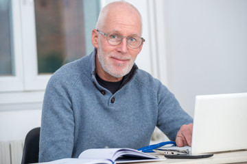 middle-aged man using laptop in his office