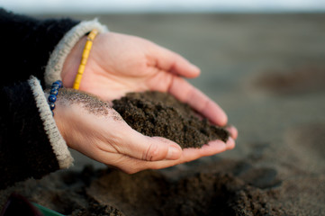 manos de mujer con arena de playa
