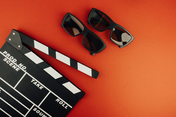 Cinema minimal concept. Watching film in the cinema. clapper board, 3d glasses, on red background. 