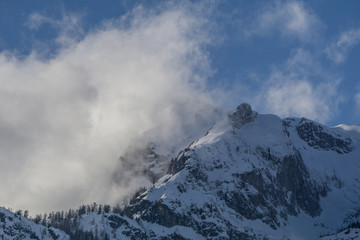 Fototapeta na wymiar Clouds rising above the snow capped tops of the Austrian Alps