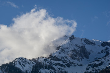 Fototapeta na wymiar Cloud smashing against the stone barrier of the Austrian Alps