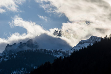 Fototapeta na wymiar Dramatic limestone mountain scenery with peaks shrouded in clouds