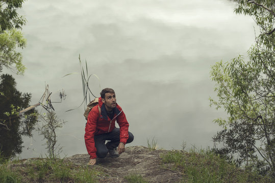 Retrato de hombre joven junto al lago Diamond en Nueva Zelanda en un día gris lleno de nubes.