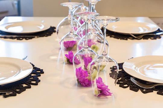Flower of feulette chrysanthemum in an inverted glass on the table. Decoration of a flower in a glass