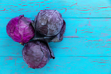 Three fresh heads of red or purple cabbage