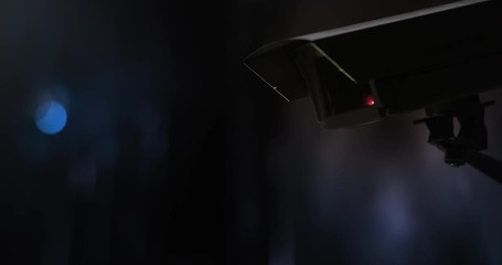 Surveillance camera in front of city lights at night