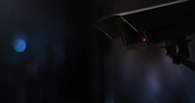 Surveillance camera in front of city lights at night