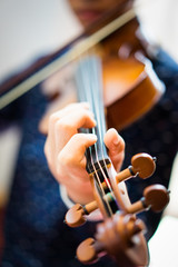 A young man is playing a violin.