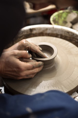Artist makes clay pottery on a spin wheel