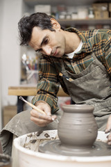 Artist makes clay pottery on a spin wheel