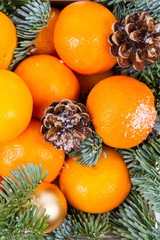 Christmas composition with tangerines, gift boxes, cones on a dark wooden background. Top view with copy space.