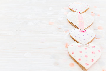 pink cookie hearts on white rustic wooden background with confetti in soft light. happy mother's day greeting card. space for text . happy valentine's day or women's. mock-up