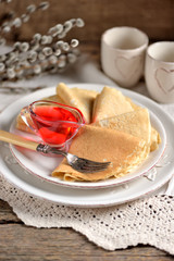 Pancakes made of oat flour with cherry syrup on an old wooden background.