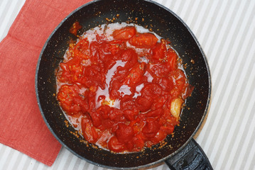 Tomatoe Sauce in Black Pant Top view. Food Preparing with Orange Napkin.