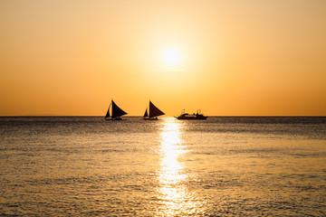 Fototapeta na wymiar Philippine traditional boat sailing in sunset. Boracay, Philippines.