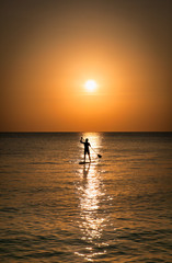 Fototapeta premium Silhouette of man standing up at paddle Board on sunset, Boracay. Philippines.