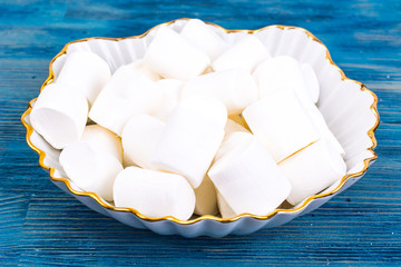 Sweet marshmallow on blue wooden background
