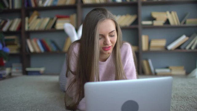 the student girl uses a laptop . Young , beautiful girl is in correspondence in social networks using laptop. 4 k Young , beautiful girl is in correspondence in social networks using laptop.
