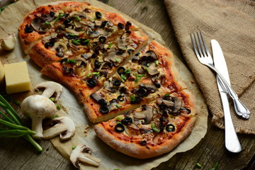 Italian pizza with mozzarella cheese, mushrooms,  black olives and green onion 