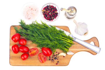 Red tomatoes and green dill on wooden background