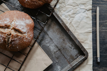 Freshly baked bread lying on a baking tray with flour