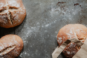 Homemade rustic bread on vintage baking tray with flour