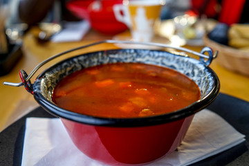 Traditional Hungarian goulash soup in a cauldron. Close up photo.