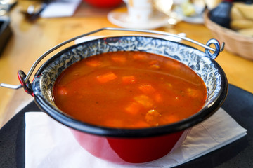Traditional Hungarian goulash soup in a cauldron. Close up photo.