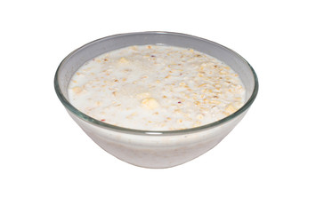 oat flakes with milk in glass transparent plate on white isolated background