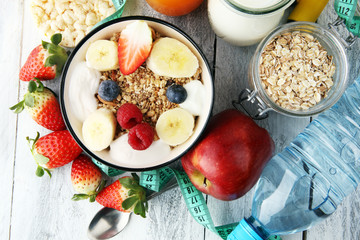 muesli with dairy and fruit, healthy lifestyle. bowl of cereal, fruit and dumbbell