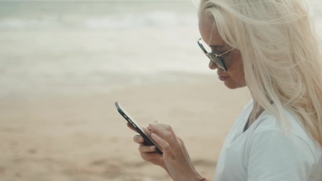 beautiful girl using mobile phone device on the beach , wireless technology