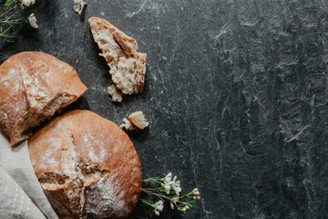 Slices of homemade bread with little white flowers on black stone