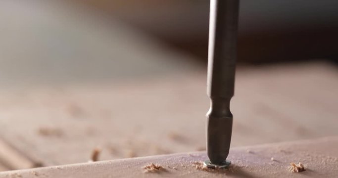 Electric driller on wooden plank