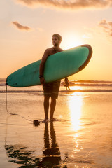 Surfer with surfboard on the beach