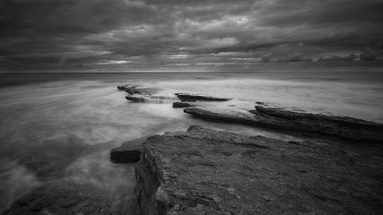 Beautiful rocky beach in the Portuguese coastline in a stormy day. Seascape. Long exposure