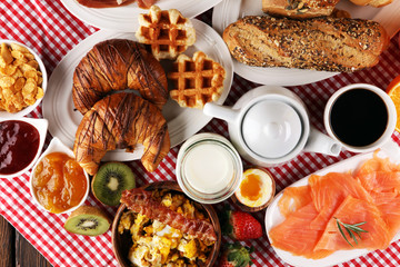 breakfast on table with waffles, croissants, coffe and juice