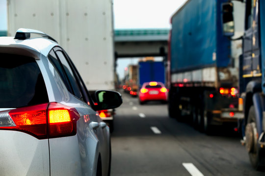 Intense Traffic Flow Of Trucks And Cars. Jam On The Highway. Road Repair Works. Rear View.