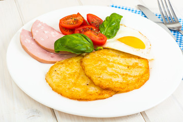 Potato pancakes, fried egg, sausage for breakfast