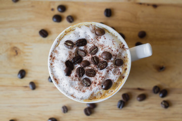 hot coffee in white cup on table with coffee beans