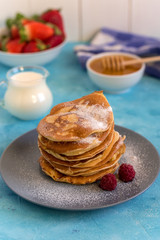 Fluffy and delicate pancakes with honey, milk and berries.