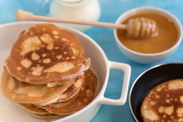 Fluffy and delicate pancakes with honey and milk.