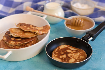 Fluffy and delicate pancakes with honey and milk.