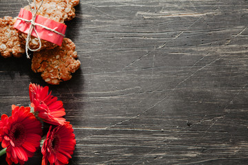 Australian oatmeal cookies close-up on dark, vintage table with red flowers