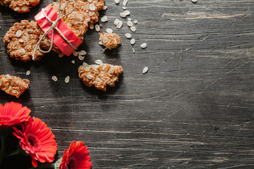 Anzac cookies with red flowers on a scratched wooden table