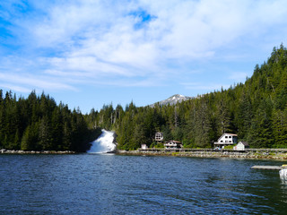 A beautiful place in alaska, where the boats can find a safe port to rest - with a amazing waterfall on the background