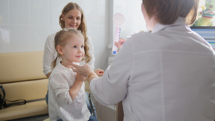 Obraz premium Diagnostic in child's ophthalmology - optometrist diagnosis little girl