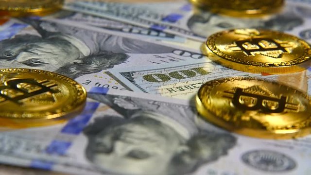 Gold coins of bitcoins and a background of hundred-dollar bills. The concept of financial operations. Economy of the future