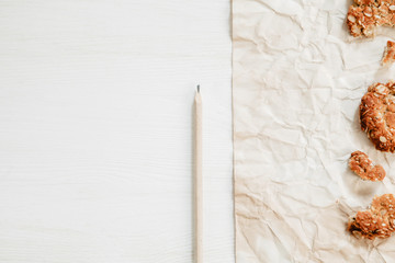 Healthy oat cookies on the white wooden table with paper and pencil