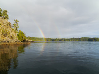 Alaska in USA cloud day with a beautiful rainbo - calm sea with mountains and trees