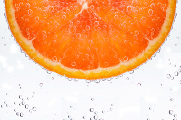 Sicilian orange. Fresh orange slice in water with bubbles. Close-up. Citrus texture